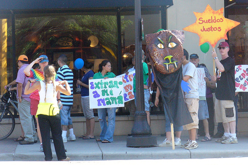 Grand Avenue serves the community as more than a shopping district.  This is a rally supporting immigrants.  (photo by Krista 76 via Flickr under a Creative Commons License atribution/noncommercial)